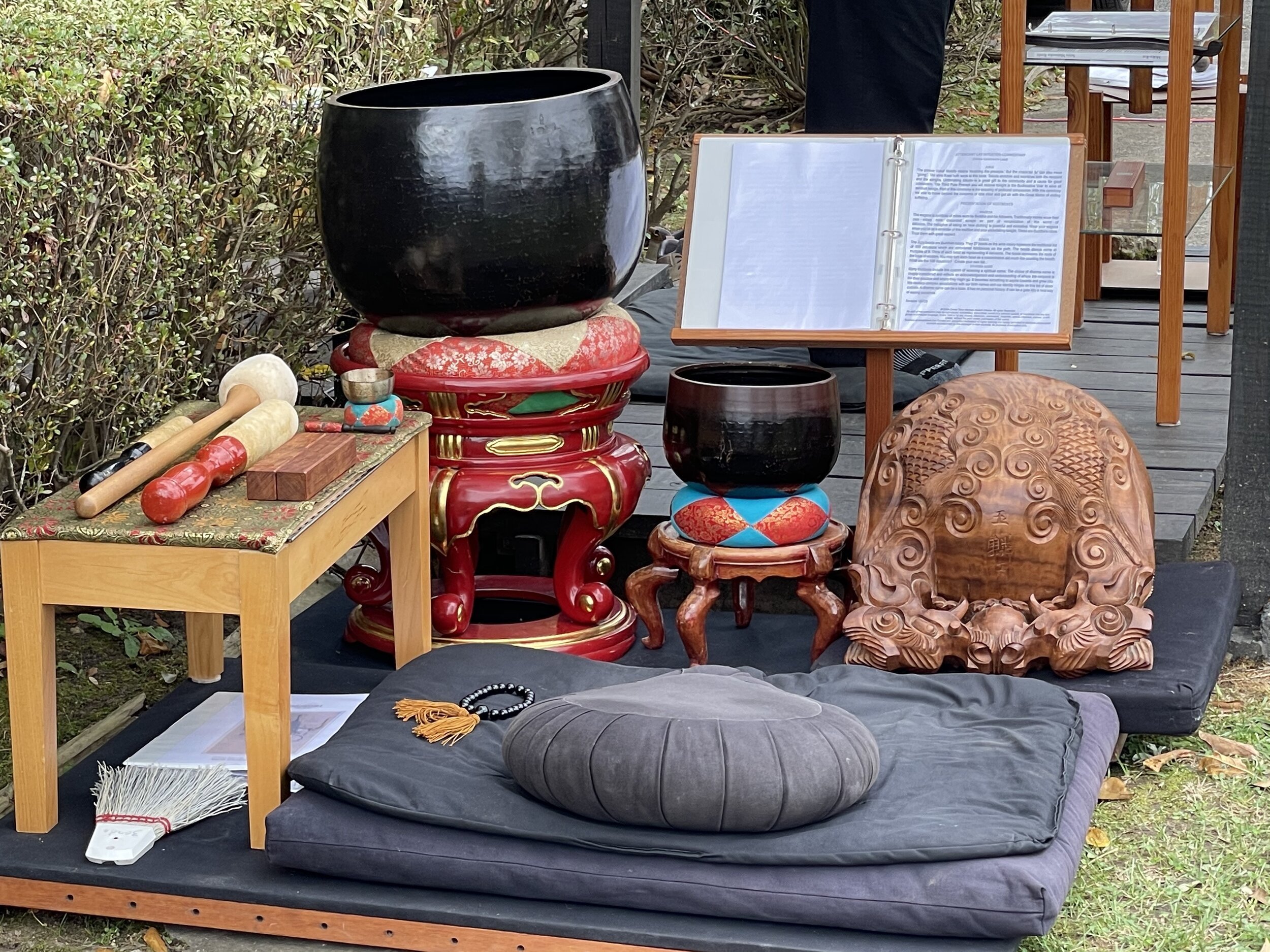 A meditation cushion by all the ritual bells and gongs and clappers involved in a Soto Zen ceremony, arranged outdoors